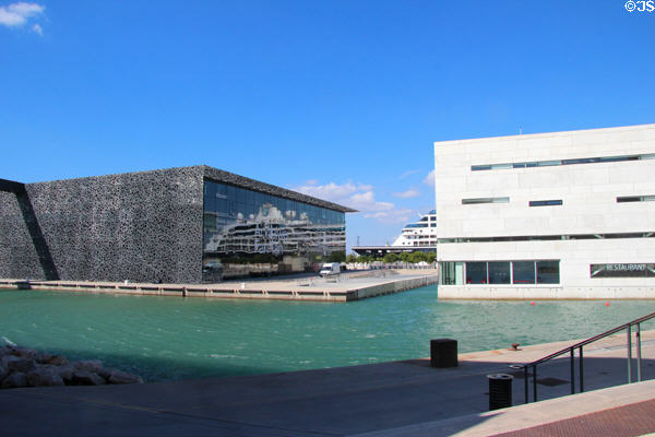 Cruise ship reflects off black MuCEM museum & white Villa Méditerranée. Marseille, France.