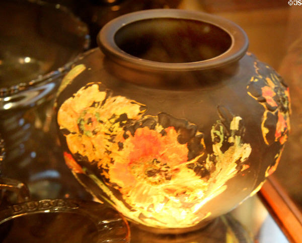 Black glass vase decorated with yellow & red flowers at Historical Glass Museum. Redlands, CA.