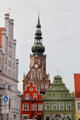 Germanic market buildings with St Nicholas Church tower beyond. Greifswald, Germany.