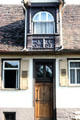 Home with tile roof with ornate dormer & carved front door. Hirsau, Germany.