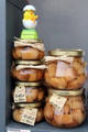 Jars of Baba au Rhum in shop window on Place St Croix. France.